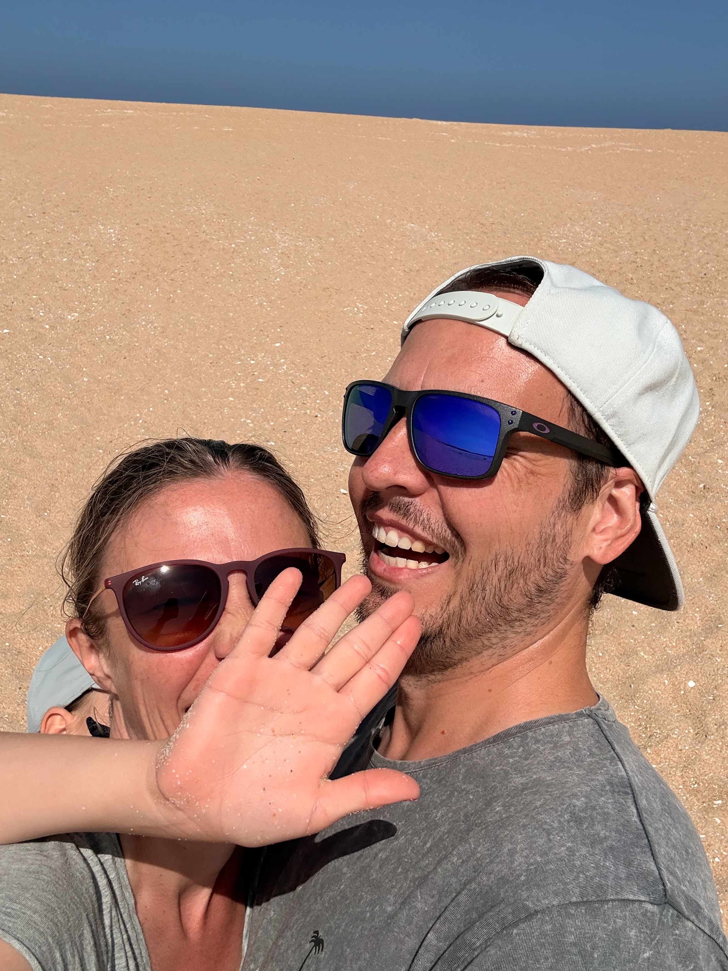 Martina und Marcel lachen gemeinsam am Strand